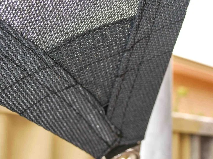 Black shade sail corner with reinforced webbing attached to a galvanised steel post